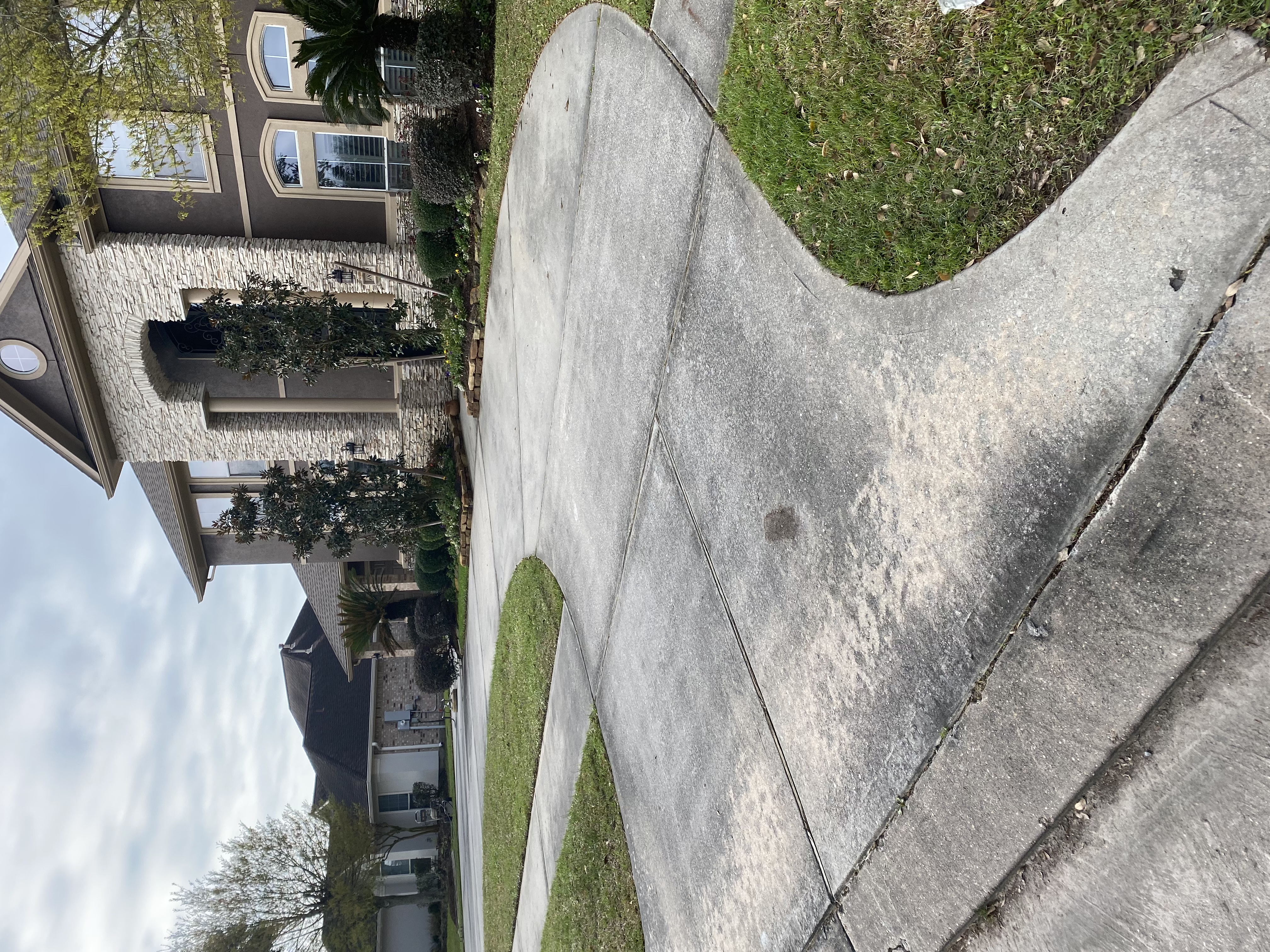 Stained stucco home driveway before
